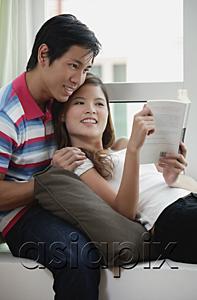 AsiaPix - Couple at home, woman leaning on man, reading a book
