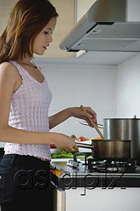 AsiaPix - Woman cooking in kitchen