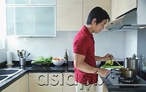 AsiaPix - Man cooking in kitchen