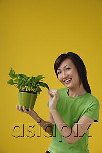 AsiaPix - Young Woman with houseplant, smiling at camera