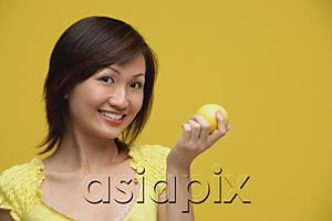 AsiaPix - Young woman holding lemon, smiling