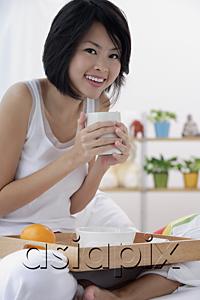 AsiaPix - Young woman holding cup of coffee, smiling at camera