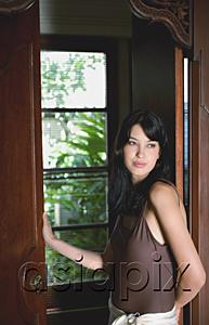 AsiaPix - Young woman leaning on door frame, looking away