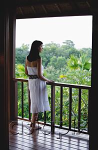 AsiaPix - Young woman standing on balcony
