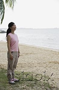 AsiaPix - Woman standing on beach, smiling