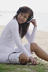 AsiaPix - Young woman listening to music, wearing headphones