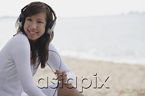 AsiaPix - Young woman wearing headphones, smiling at camera