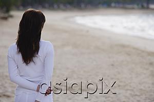 AsiaPix - Young woman standing on beach, rear view