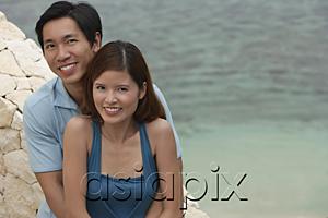 AsiaPix - Couple looking at camera, sea behind them
