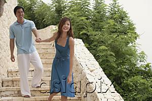 AsiaPix - Couple walking down stairs, woman pulling man behind her