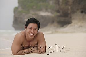 AsiaPix - Man lying on beach, arms crossed