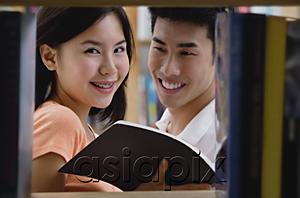 AsiaPix - Couple in library, woman looking at camera