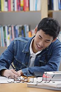 AsiaPix - Young man in library, writing