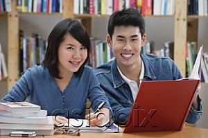 AsiaPix - Couple studying in library, smiling at camera