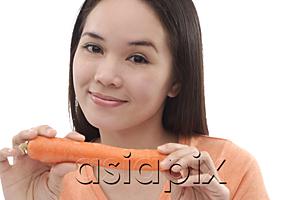 AsiaPix - Young woman holding a carrot