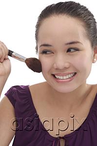 AsiaPix - Young woman applying make-up