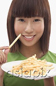 AsiaPix - Young woman holding a plate of French fries