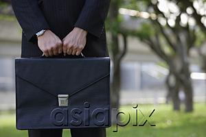 AsiaPix - Businessman holding briefcase, cropped image