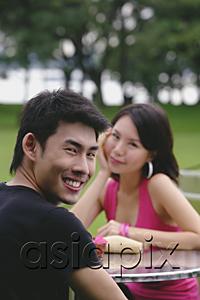 AsiaPix - Man turning to smile at camera, woman in the background