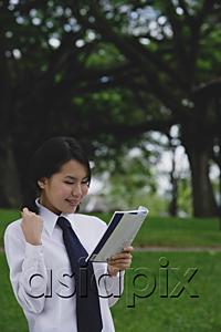 AsiaPix - Young woman in school uniform, reading a book