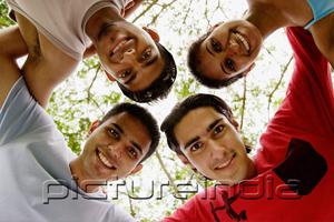 PictureIndia - Group of friends, arms around each other, looking down at camera