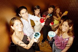 PictureIndia - Young adults toasting with drinks, looking at camera
