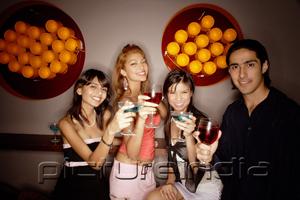 PictureIndia - Young adults holding drinks out towards camera