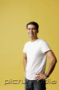 PictureIndia - Man standing, hands on hips, looking at camera