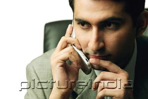 PictureIndia - Businessman using mobile phone, looking away