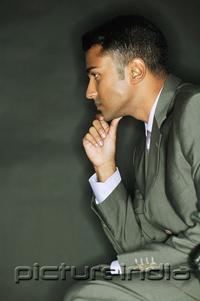 PictureIndia - Businessman with hand on chin, looking away