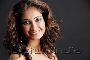 PictureIndia - Woman looking at camera, smiling, head shot