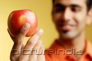 PictureIndia - Man holding apple in hand, selective focus