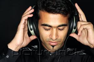 PictureIndia - Man listening to music with headphones