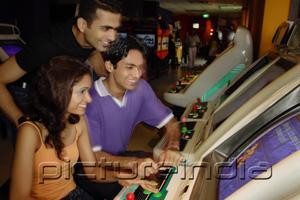 PictureIndia - Young adults in video arcade