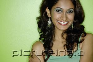 PictureIndia - Young woman in green tank top, looking at camera, smiling