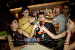 PictureIndia - Young adults in club, toasting with drinks
