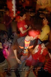PictureIndia - Young adults dancing in night club, high angle view
