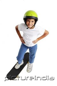 PictureIndia - Boy with helmet, standing on skateboard, hand on hip