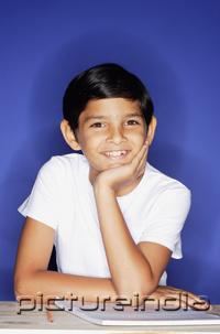 PictureIndia - Boy looking at camera, hand on chin