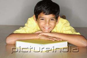 PictureIndia - Boy lying on floor, leaning on book