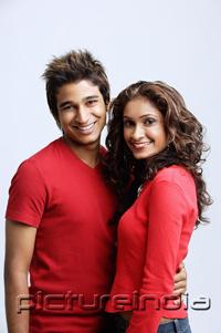 PictureIndia - Couple standing side by side, smiling at camera