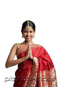 PictureIndia - Woman in traditional Indian costume, standing with hands together, smiling at camera