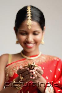 PictureIndia - Woman in sari, holding oil lamp