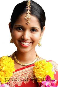 PictureIndia - Woman in sari wearing a garland, smiling at camera, head shot