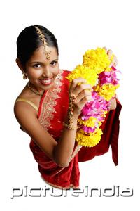 PictureIndia - Woman in sari, holding flower garland, high angle view
