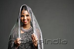 PictureIndia - Woman in gray sari smiling at camera, portrait