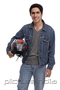 PictureIndia - Man carrying motorcycle helmet, looking at camera