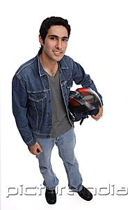 PictureIndia - Man carrying motorcycle helmet, looking up at camera