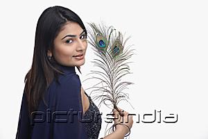 PictureIndia - Woman looking at camera, holding peacock feather