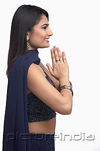 PictureIndia - Woman in traditional Indian clothing, hands together, side view